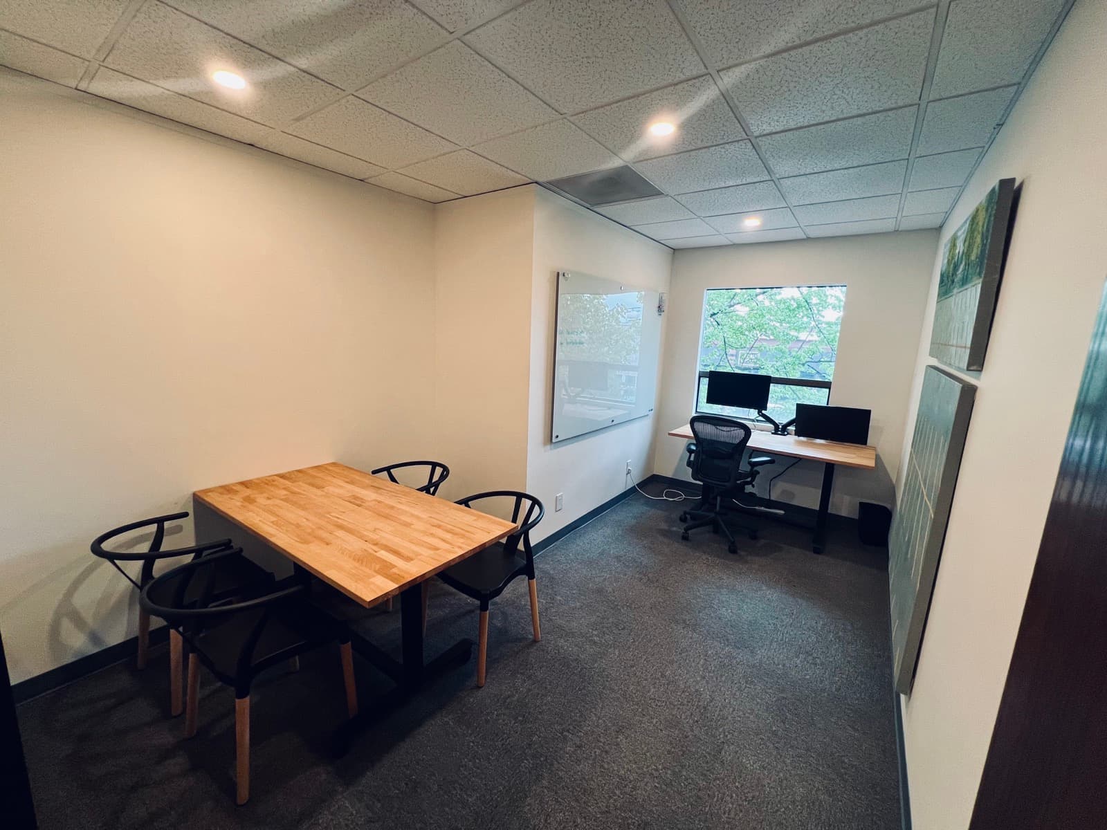 Meeting room at Host Studios with a table, chairs, whiteboard, and a desk by the window